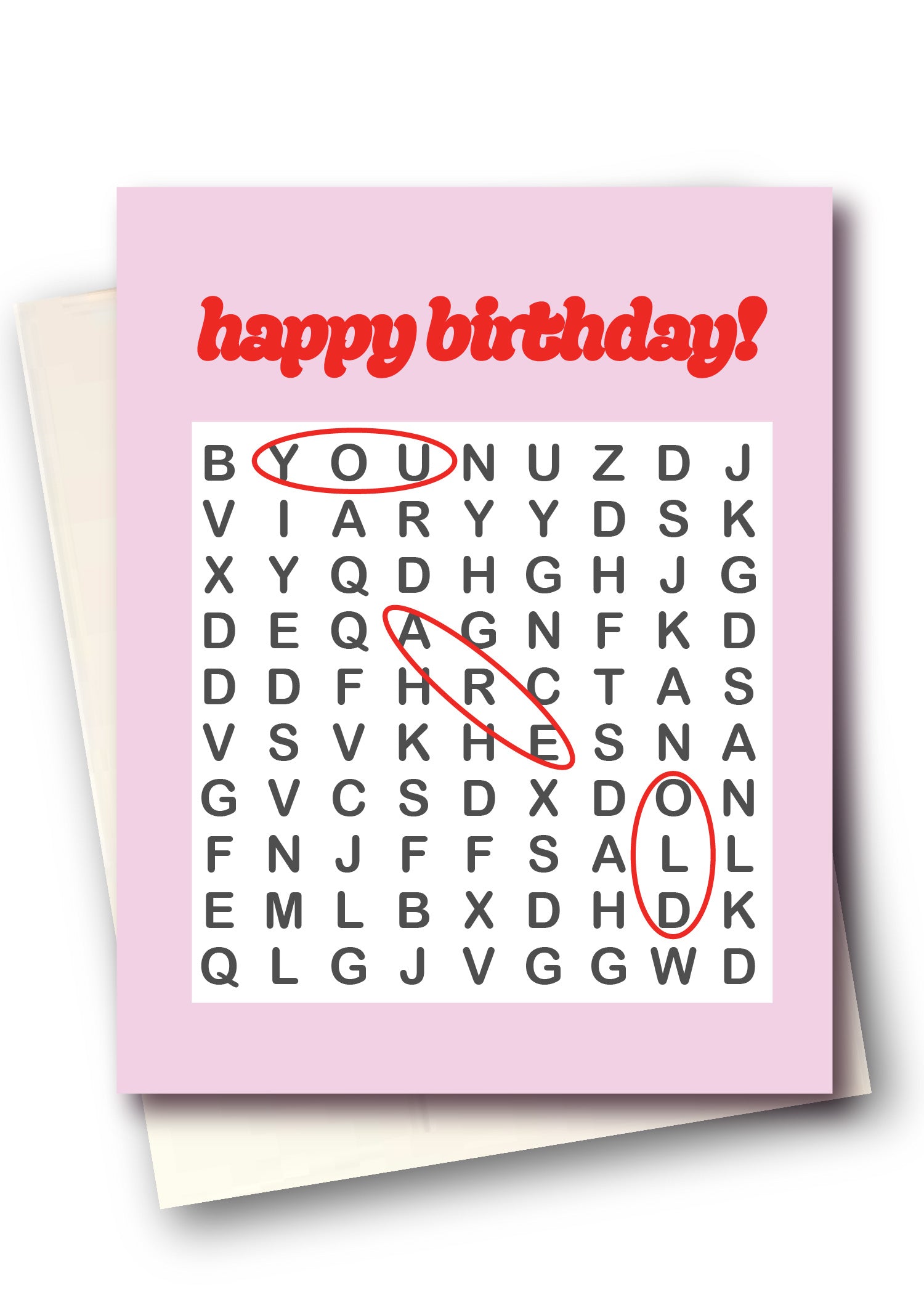A pink birthday card with a word search puzzle and red handwritten-style circles highlighting words, shown with a white envelope behind it on a white background.