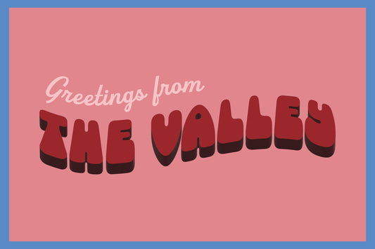 A postcard set showing the front and back on a white background. The front has a pink background with a blue border and the text 'Greetings from THE VALLEY' in stylized red letters.