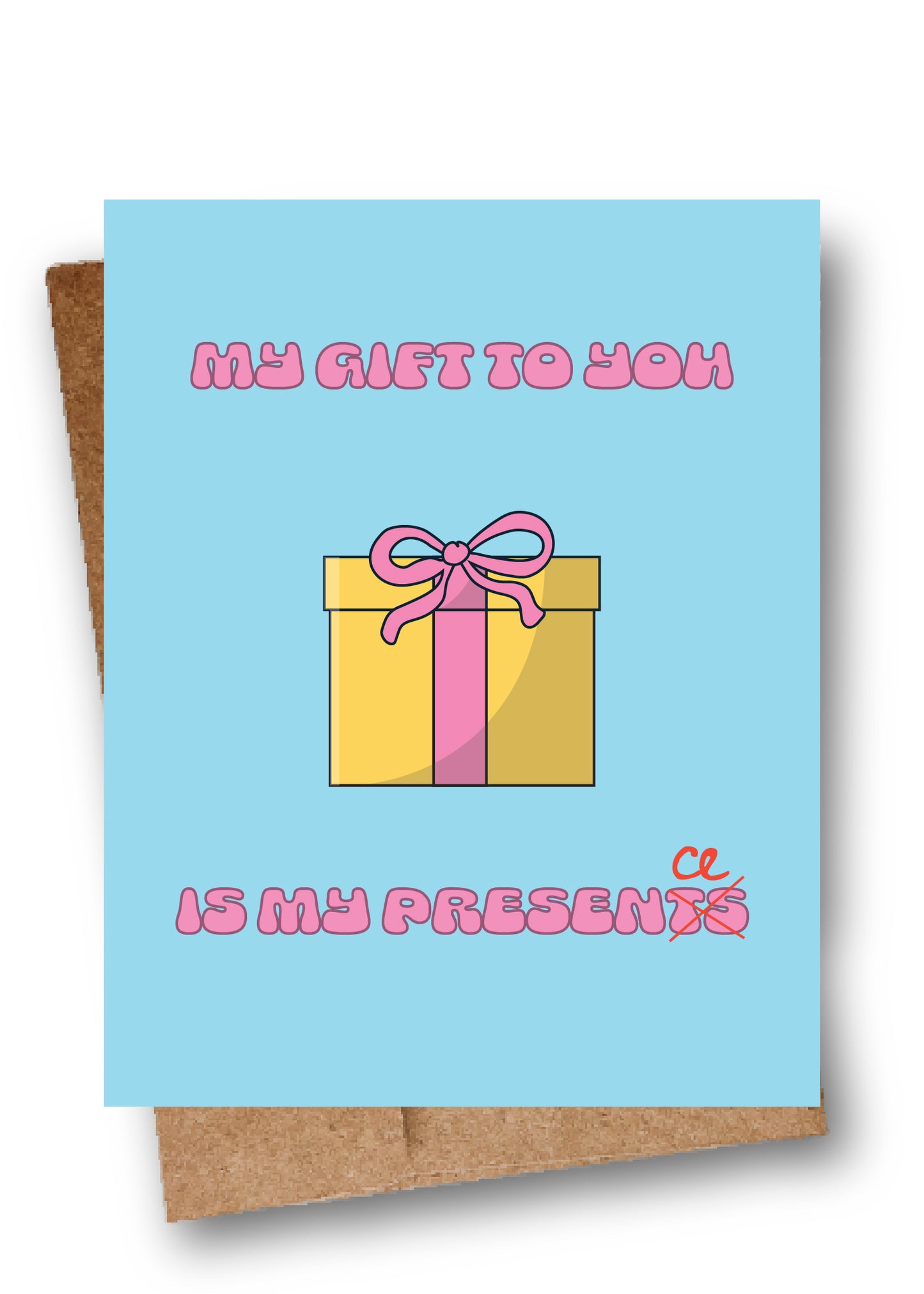 A square greeting card with a light blue background, featuring a cartoon gift box with pink ribbon and the text 'MY GIFT TO YOU IS MY PRESENT' in pink bubble letters. A brown kraft envelope is partially visible behind the card.