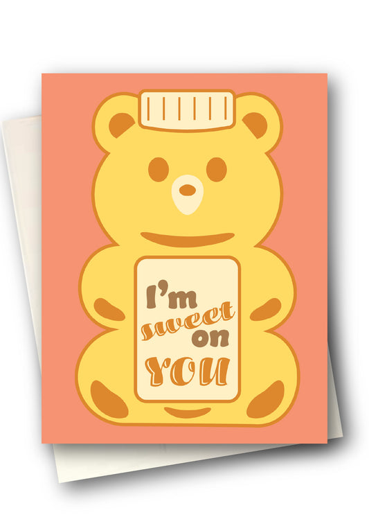 Greeting card with a honey bear design and text on a coral background